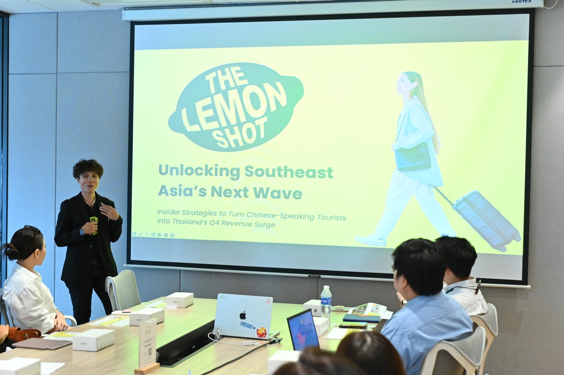 A presenter speaking in front of a slide titled 'Unlocking Southeast Asia's Next Wave' about Chinese-speaking tourists to Thailand