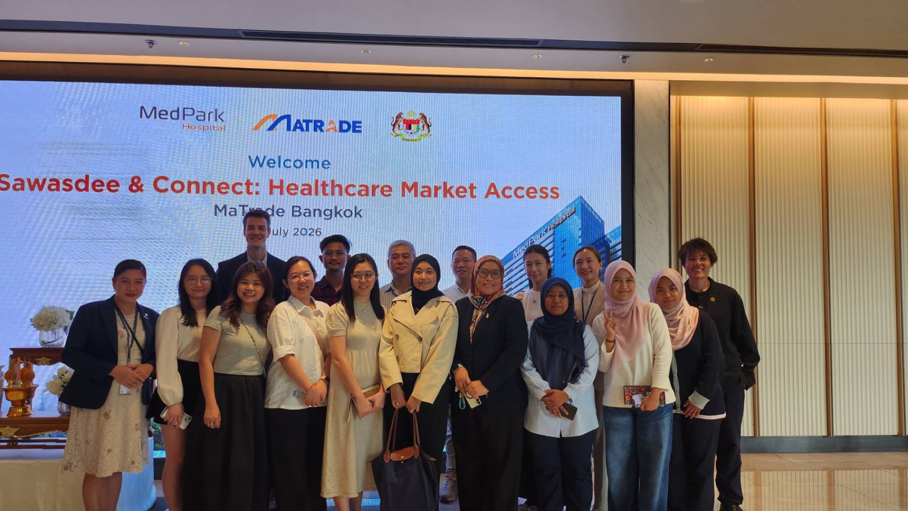 Delegates posing in front of a welcome screen for a Malaysia trade board and MedPark Hospital healthcare market-access event in Bangkok